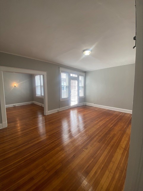 an empty living room with a hard wood floor